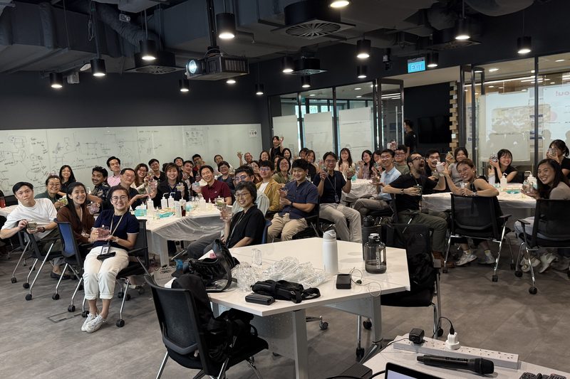 A large team seated at long tables in an office during a hands-on White Pixies workshop