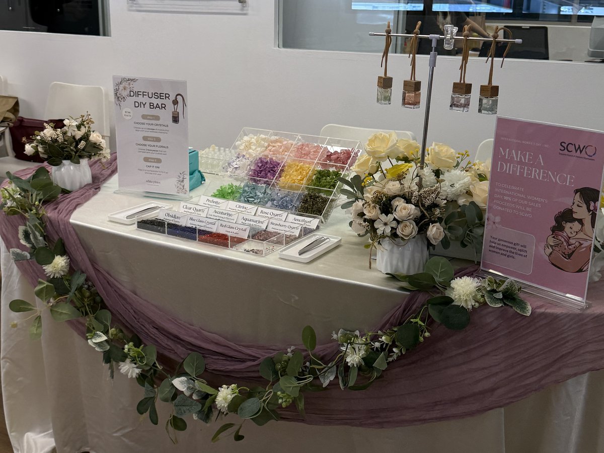 A scent and reed diffuser DIY bar with glass bottles, dried flowers and signage at an event