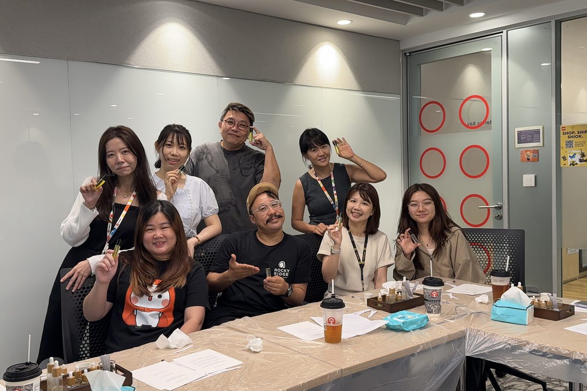 Colleagues holding up the candles they made together at a White Pixies team session