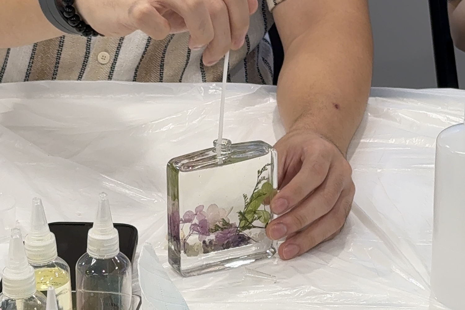 A finished botanical reed diffuser with dried flowers