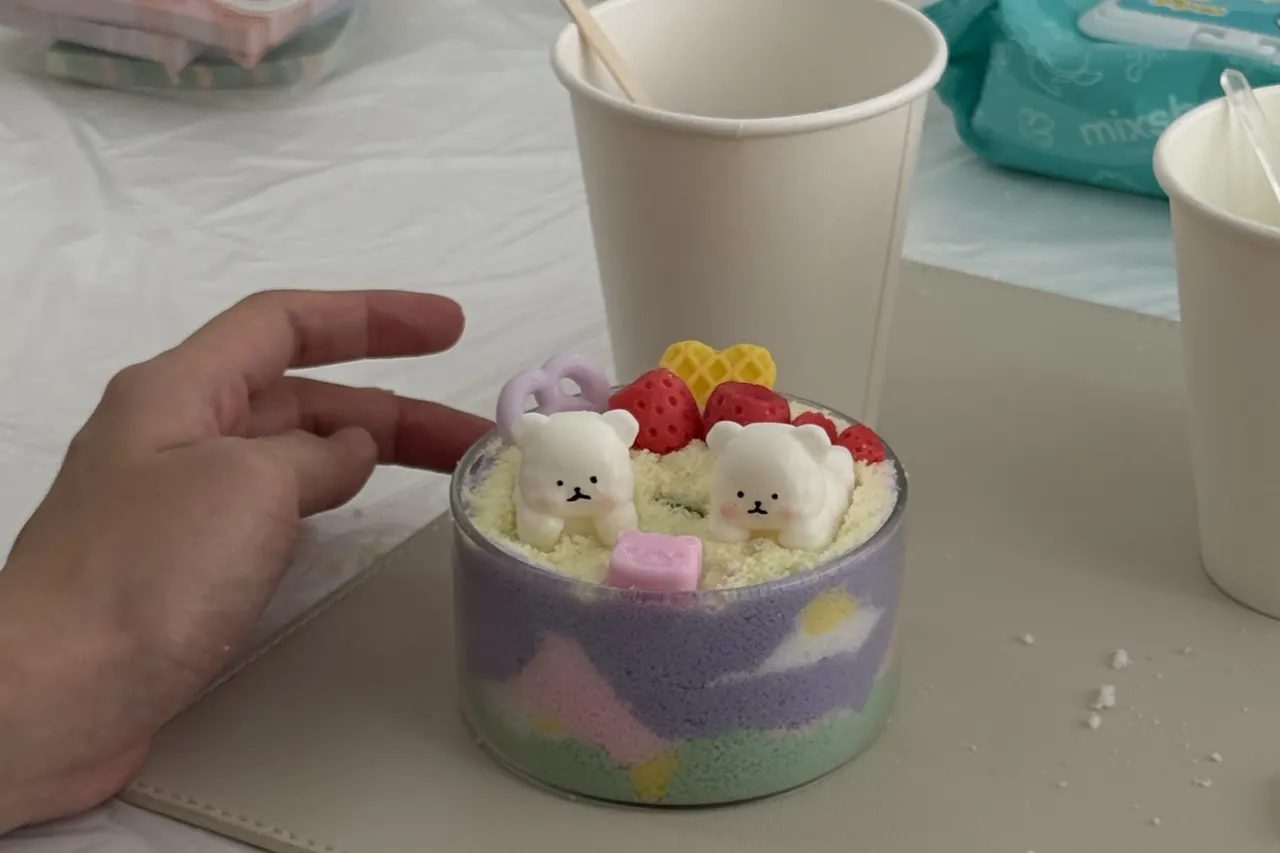A colourful layered sand art candle